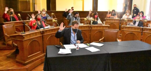 alt="concejales levantan la mano aprobando la resolución"