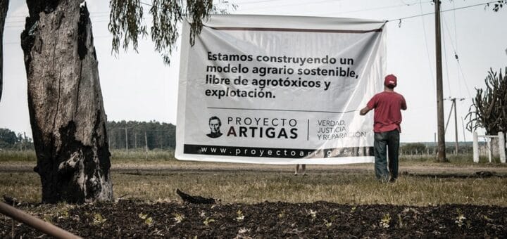 alt="pancarta del Proyecto Artigas en el campo en disputa"