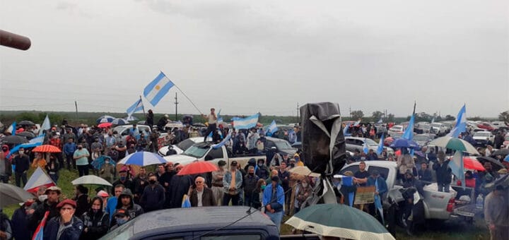 alt="ruralistas acampan frente a campo en disputa"