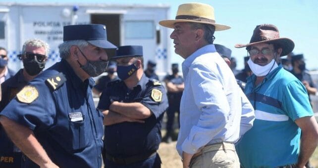 alt="luis etchevehere habla con un jefe de la policía"