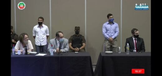 alt="los acusados Agüero y Moledo parados detrás de sus abogados defensores"