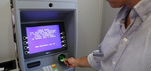 alt="cajero automático con una persona introduciendo una tarjeta"