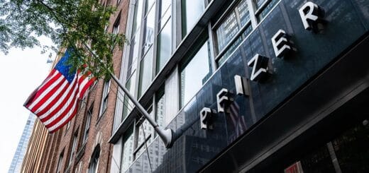 alt="sede de la farmacéutica Pfizer con bandera de los Estados Unidos"