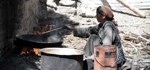 alt="mujer en condiciones de pobreza prepara su alimento"