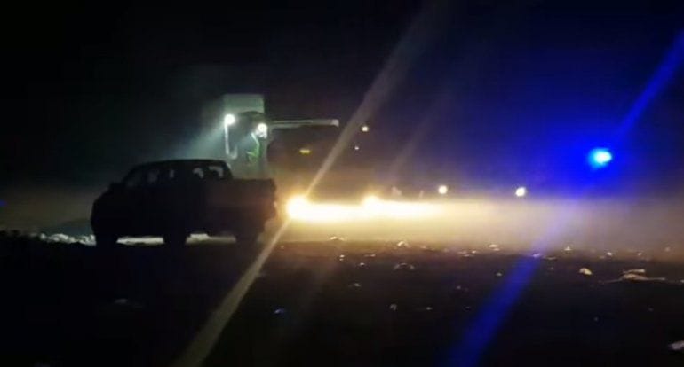 alt="camión de residuos en volcadero de basura y camioneta de la policía"