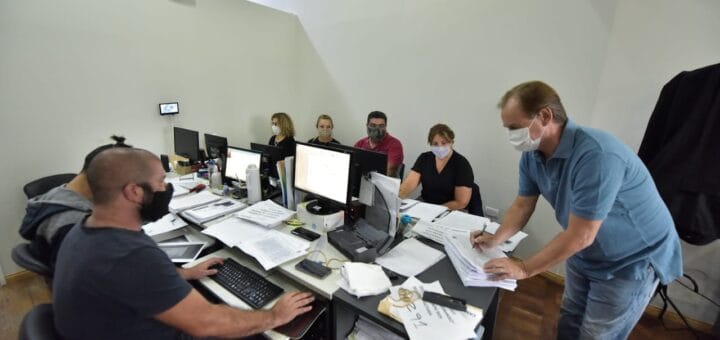 alt="Borde firma un documento ante una persona en un escritorio"