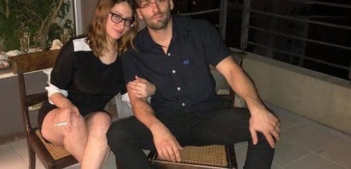 alt="julieta riera y jorge julián christe sentados cerca de un balcón"