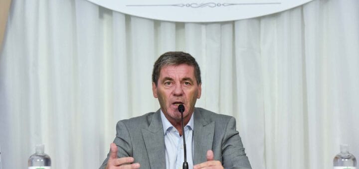 alt="ministro de economía de Entre Ríos, Hugo Ballay, sentado frente a un micrófono"