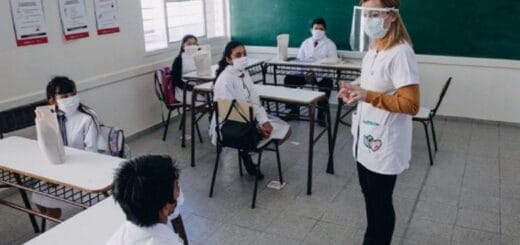 alt="maestra enseña a alumnos bajo protocolos para el covid"