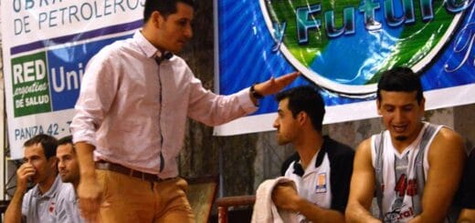 alt="el entrenador Mariano Panizza saluda a sus jugadores sentados en el banco de suplentes"