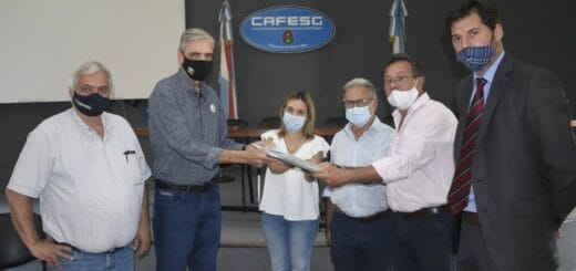 alt="en primer plano, funcionarios de cafesg entregan el proyecto del nuevo edificio a autoridades de la uader"