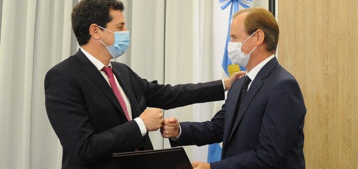 alt="dos hombres golpeando sus puños cerrando un trato por la deuda provincial"