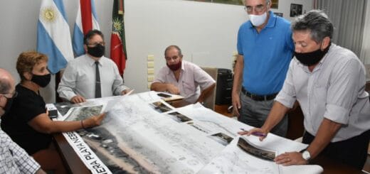 alt="se ve a seis personas que examinan el plano proyectado de la nueva costanera nébel"