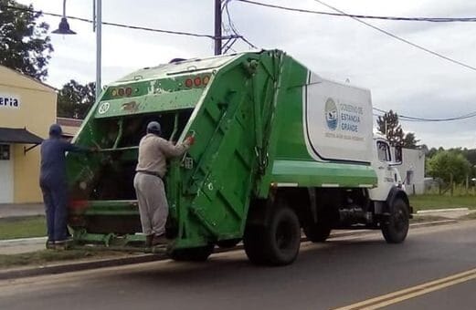 alt="camión compactador de residuos transitando por la calle"