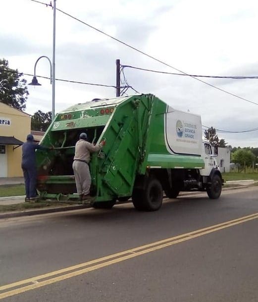 alt="camión compactador de residuos transitando por la calle"