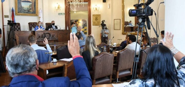alt="en la foto, concejales de paraná levantan la mano para aprobar el aumento del boleto de colectivo"