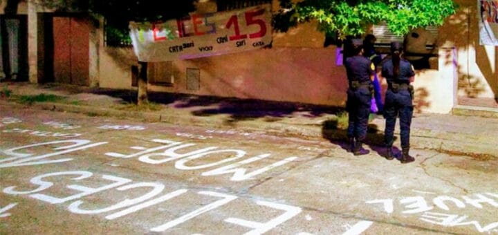 alt="dos policías mujeres, en la calle, mirando hacia una vivienda"