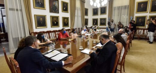 alt="gremialistas junto a funcionarios negocian en una mesa"