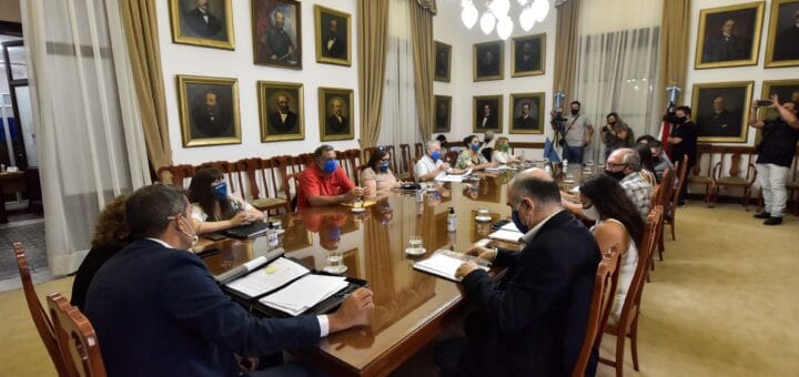alt="gremialistas junto a funcionarios negocian en una mesa"