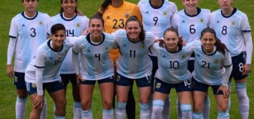 alt="integrantes del seleccionado argentino femenino de fútbol posan en un campo de juego"