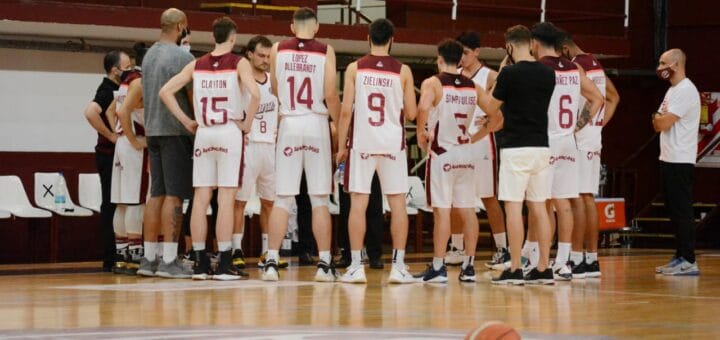 alt="integrantes de un equipo de básquet reciben instrucciones en el entretiempo"