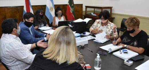 alt="en la imagen se ven siete personas sentadas alrededor de una mesa"