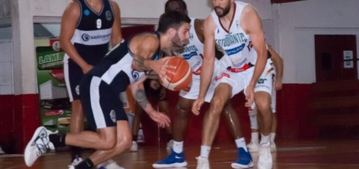alt="un jugador de gimnasia pical apelota ante la marca de uno de estudiantes, detràs de ambos hay màs jugadores"