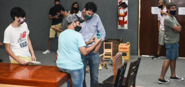 alt="siete personas recorren la exposición de muebles de la CAFESG"