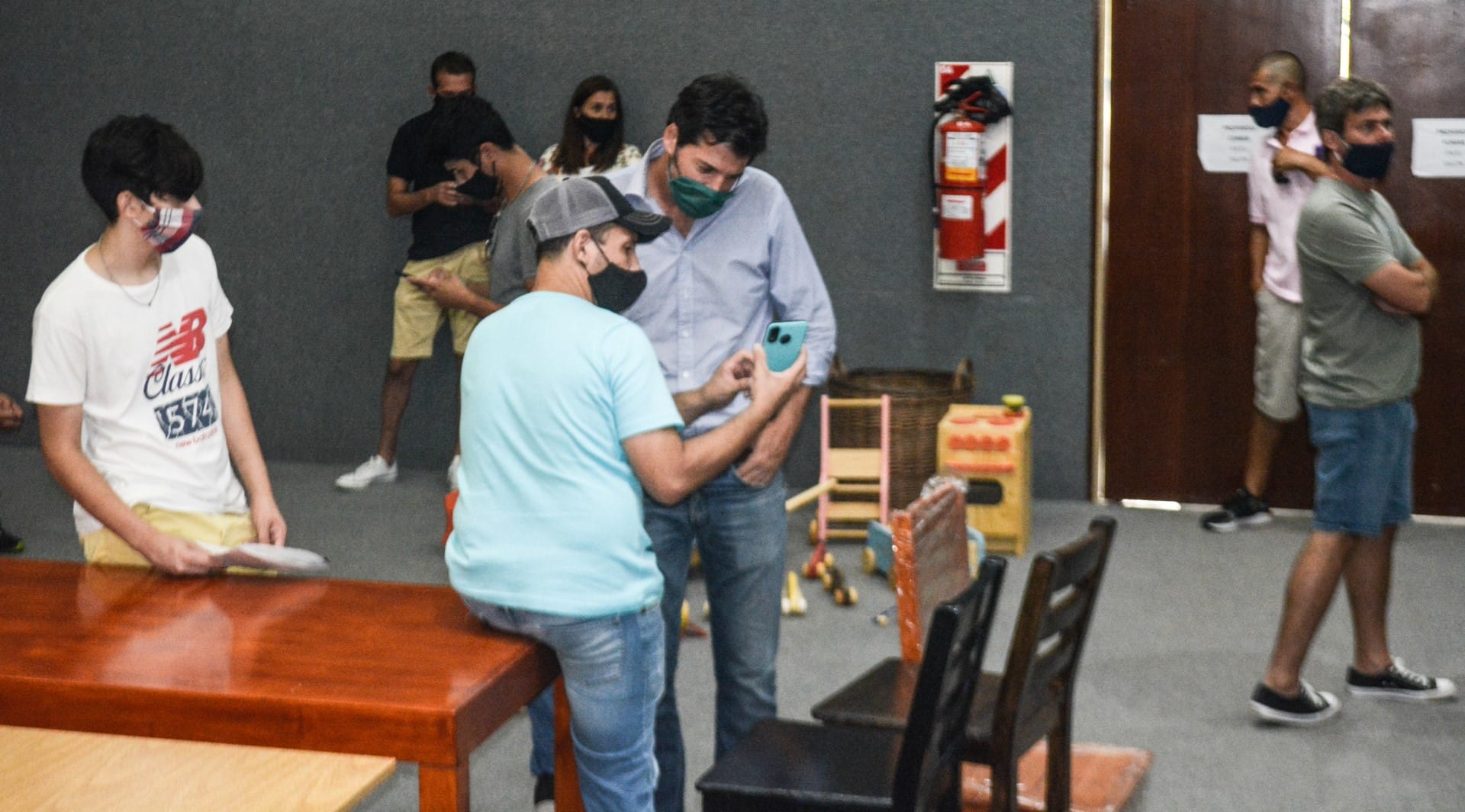 alt="siete personas recorren la exposición de muebles de la CAFESG"