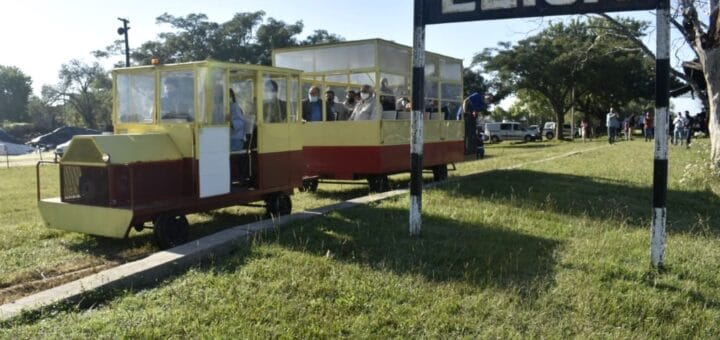 alt="estación ferroviaria de villa elisa, en las vías una locomotora y un vagón con pasajeros"