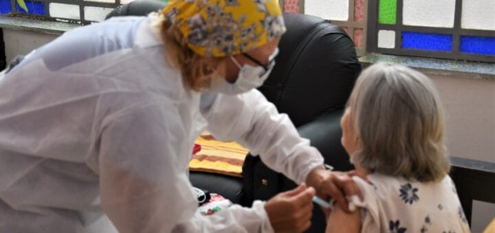 alt="aplican una vacuna a una residente de un hogar de ancianos"