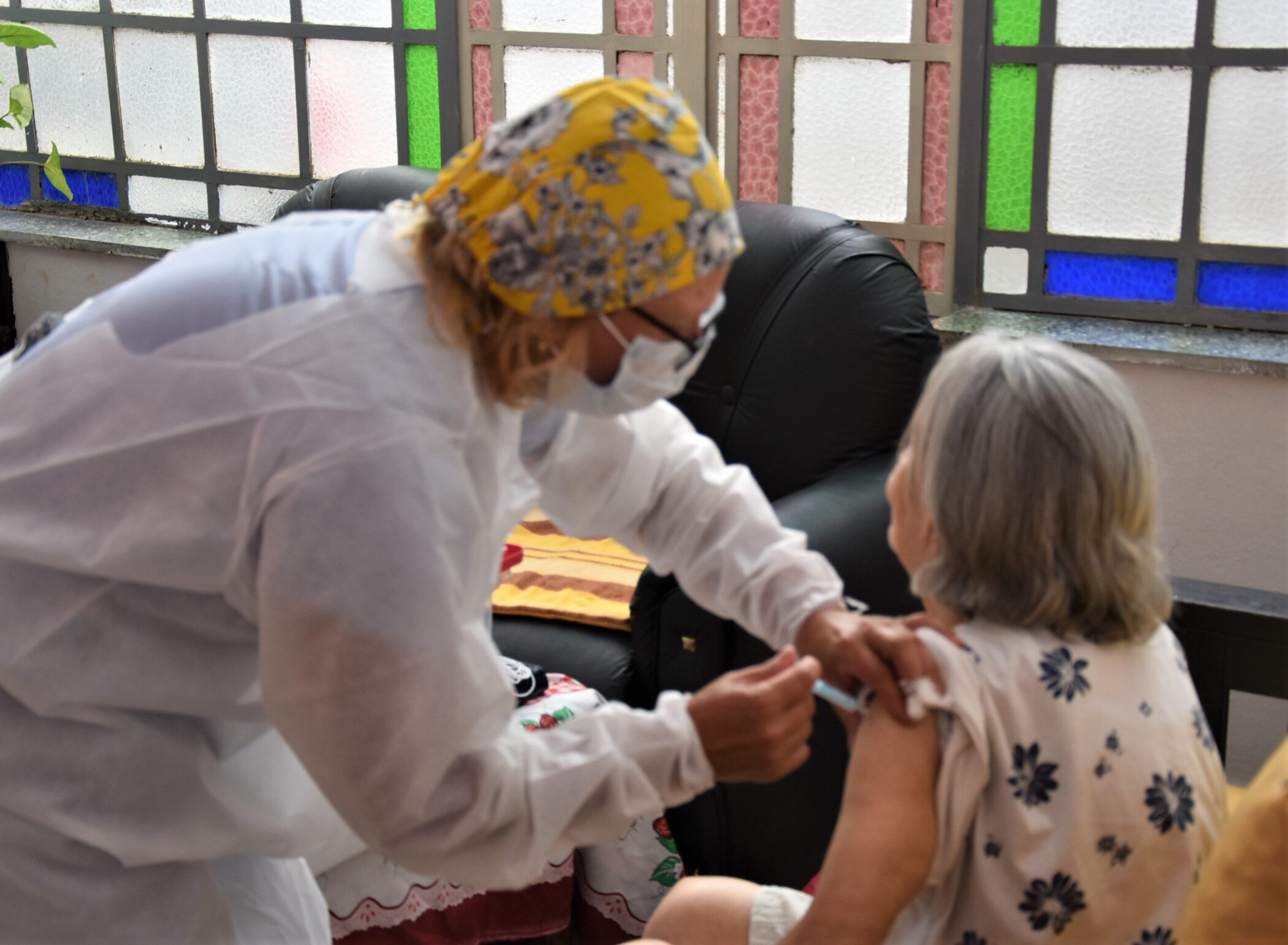 alt="aplican una vacuna a una residente de un hogar de ancianos"