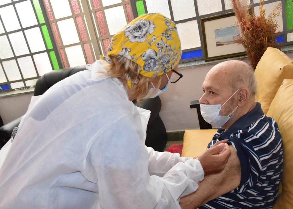 alt="en la foto, una enfermera vacuna a un hombre"