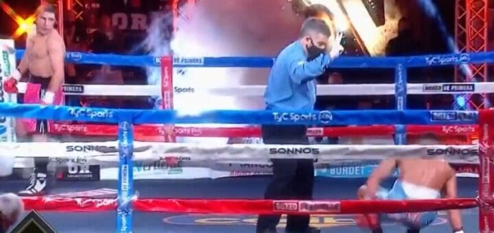 alt="en la foto, el árbitro realiza la cuenta ante un boxeador tirado en el ring, su rival lo mira desde una esquina"