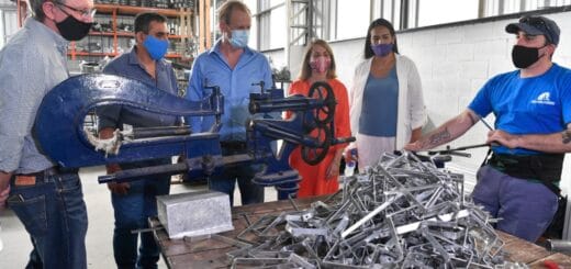 alt="cinco personas observan el trabajo de un operario de una empresa metalúrgica"