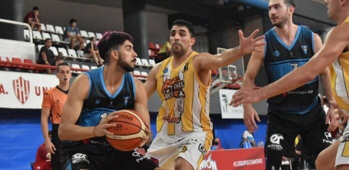 alt="en la fotografía, tras jugadores de básquet se disputan un balón"
