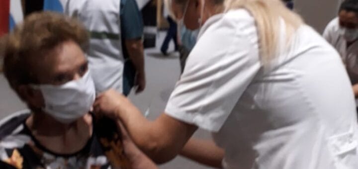 alt="enfermera vacuna a una mujer en el brazo izquierdo en el centro de convenciones de concordia"