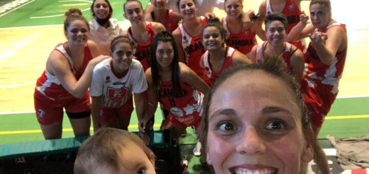 alt="una selfie de una jugadora con un bebé en primer plano, detrás las jugadoras de rocamora"