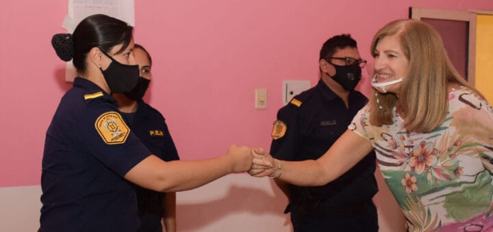 alt="la ministra Rosario Romero saluda a una mujer policía, detrás un policía hombre y una policía mujer"