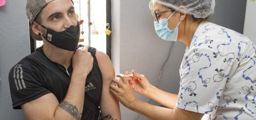 alt="un hombre joven recibe una vacuna contra el coronavirus"