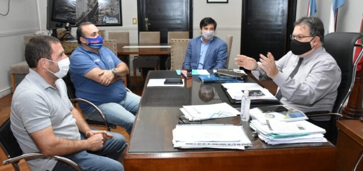 alt="en la fotografía puede verse cuatro personas sentadas alrededor de una mesa, pudiendo ser el intendente, el jefe de gabinete municipal y el presidente y el vicepresidente del Auto Moto Club"