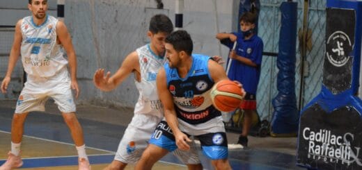 alt="un jugador de basquet cubre la pelota con su cuerpo ante la marca de un rival"