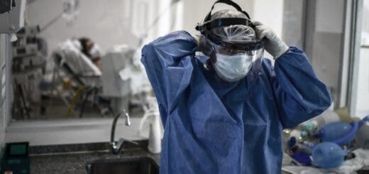 alt="un trabajador de la salud se ajusta el barbijo en la sala de un centro asistencial"