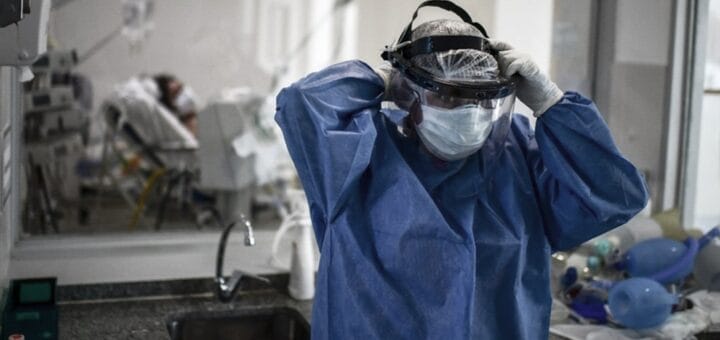 alt="un trabajador de la salud se ajusta el barbijo en la sala de un centro asistencial"