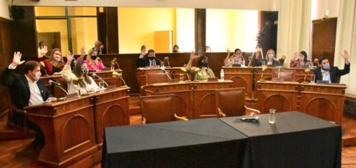 alt="concejales en sus bancas levantan las manos en una votación"