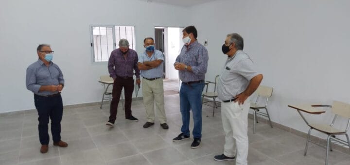 alt="cuatro hombres en un salón"