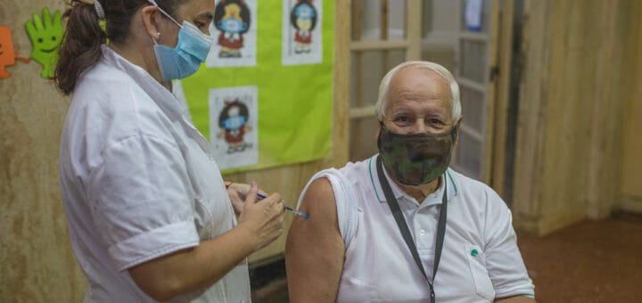 alt="u hombre recibe una vacuna y una enfermera la aplica"