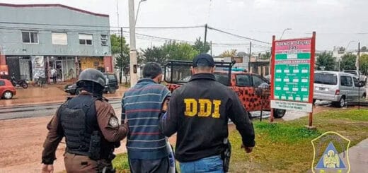 alt="dos policías llevan detenida a una persona"
