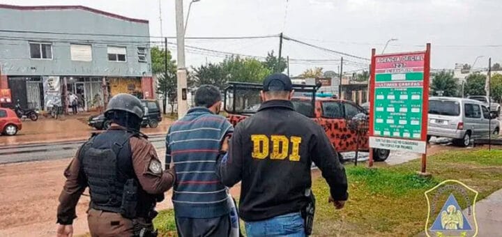 alt="dos policías llevan detenida a una persona"