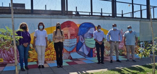 alt="funcionarios provinciales y vecinos posan ante un mural"